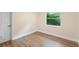 A clean room with light-colored walls, wood floors, white trim, and a bright window at 5815 Holmes Dr, Orlando, FL 32808