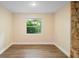 An empty room with light-colored walls, wood floors, and a bright window at 5815 Holmes Dr, Orlando, FL 32808