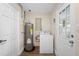Functional laundry room with washer, hot water tank, and access to the outdoors at 5815 Holmes Dr, Orlando, FL 32808