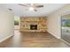 Spacious living room featuring a stone fireplace, wood floors, and a modern ceiling fan at 5815 Holmes Dr, Orlando, FL 32808