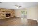 Bright living room with stone fireplace, wood floors, and sliding glass doors at 5815 Holmes Dr, Orlando, FL 32808
