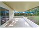 Covered back patio featuring a large sliding glass door and view to greenery beyond the yard at 5815 Holmes Dr, Orlando, FL 32808