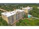 Aerial view of condo buildings with a pool, surrounded by lush greenery and serene lakes at 6336 Buford St # 207, Orlando, FL 32835