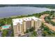 Stunning aerial view of condo community with pool, lush surroundings, and lake backdrop at 6336 Buford St # 207, Orlando, FL 32835