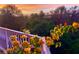 Balcony view with bright yellow flowers with trees in the background at sunset at 6336 Buford St # 207, Orlando, FL 32835