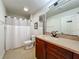 Functional bathroom with a cherry wood vanity, neutral-colored countertops, and shower with white curtain at 6336 Buford St # 207, Orlando, FL 32835