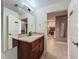 Well-maintained bathroom with a traditional wood vanity and access to other rooms in the home at 6336 Buford St # 207, Orlando, FL 32835