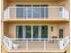 Multi-story building with private balconies, white railings, and multiple glass doors and windows at 6336 Buford St # 207, Orlando, FL 32835