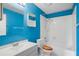 Bathroom with bright blue walls, white toilet and shower/tub combination at 6809 Magnolia Pointe Cir, Orlando, FL 32810