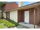 Charming townhome with a front door, brown and beige siding, chimney, and green lawn at 6809 Magnolia Pointe Cir, Orlando, FL 32810
