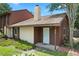 Charming townhome with a front door, brown and beige siding, chimney, and green lawn at 6809 Magnolia Pointe Cir, Orlando, FL 32810