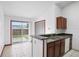 A brightly lit eat-in kitchen with gray counters and an exterior sliding glass door at 6809 Magnolia Pointe Cir, Orlando, FL 32810