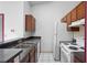 Standard kitchen with white appliances, gray counters and wood cabinets in a well lit room at 6809 Magnolia Pointe Cir, Orlando, FL 32810