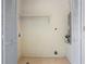 Utility room with white walls and tiled floors, featuring an open shelf and door at 6809 Magnolia Pointe Cir, Orlando, FL 32810