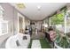 A large back porch is set up with neutral walls, and various furniture at 7642 Park Hill Ave, Leesburg, FL 34748