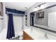 A full bathroom features an extended double sink vanity with updated lighting, full mirror, and shower-tub combination at 7642 Park Hill Ave, Leesburg, FL 34748