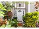 Inviting front entryway with a white door, lush landscaping, and a welcoming 'Bless this Home' doormat at 7642 Park Hill Ave, Leesburg, FL 34748
