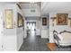 Open hallway with decorative wall art, tile flooring, and a view into the dining area at 7642 Park Hill Ave, Leesburg, FL 34748