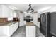 Well-lit kitchen featuring white cabinetry, granite countertops, and modern appliances at 7642 Park Hill Ave, Leesburg, FL 34748