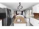 Open-concept kitchen with stainless steel appliances, granite countertops, and an island that overlooks the living area at 7642 Park Hill Ave, Leesburg, FL 34748