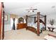 Spacious main bedroom with a four-poster bed, complemented by a dresser and serene decor at 7642 Park Hill Ave, Leesburg, FL 34748