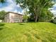 Spacious backyard with lush green grass, mature trees, and a partially fenced-in area for privacy at 8330 Lainie Ln, Orlando, FL 32818