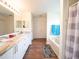 Bathroom featuring a soaking tub, double sink vanity with white cabinetry, and hardwood flooring at 8330 Lainie Ln, Orlando, FL 32818