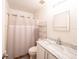 This bathroom features white cabinets, a marble countertop, a shower with curtain, and a mirror at 8330 Lainie Ln, Orlando, FL 32818