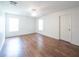Bedroom with hardwood floors, neutral walls, ceiling fan, and two large windows at 8330 Lainie Ln, Orlando, FL 32818