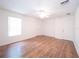 Bedroom with hardwood floors, neutral walls, ceiling fan, and two windows at 8330 Lainie Ln, Orlando, FL 32818