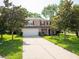 Inviting two-story home with a large front yard, two-car garage, red shutters and a well-maintained lawn at 8330 Lainie Ln, Orlando, FL 32818