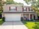 Charming two-story home featuring a spacious two-car garage, front porch, red shutters and manicured lawn at 8330 Lainie Ln, Orlando, FL 32818