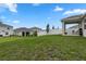 Spacious backyard featuring lush green grass, a white fence, and a covered patio area for outdoor entertaining at 884 Laurel View Way, Groveland, FL 34736