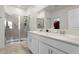 Bright bathroom features a double sink vanity, glass-enclosed shower, and tile flooring at 884 Laurel View Way, Groveland, FL 34736