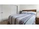 Bedroom showcasing carpet, a bed with a blue accent comforter, and a closet door at 884 Laurel View Way, Groveland, FL 34736