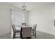 Bright dining area features a modern chandelier and sliding glass door with vertical blinds at 884 Laurel View Way, Groveland, FL 34736