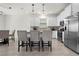 Kitchen features stainless steel appliances, white cabinetry, pendant lights, and tile flooring at 884 Laurel View Way, Groveland, FL 34736