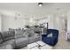 Open-concept living room seamlessly connects to a modern kitchen with stainless steel appliances at 884 Laurel View Way, Groveland, FL 34736
