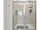 Walk-in shower features tile surround, a built-in shelf, and grab bars for accessibility at 884 Laurel View Way, Groveland, FL 34736