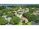 Expansive aerial view showcases a neighborhood with mature trees, lush landscaping, and a glimpse of a tranquil lake at 9491 Wickham Way, Orlando, FL 32836
