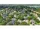Overhead view of a residential neighborhood featuring lush greenery, mature trees, and diverse rooftops at 9491 Wickham Way, Orlando, FL 32836