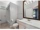 A well-lit bathroom features a vanity with a large mirror and a combined shower and tub at 9491 Wickham Way, Orlando, FL 32836