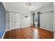 A large bedroom with hardwood floors and neutral colors offers ample space for furniture and relaxation at 9491 Wickham Way, Orlando, FL 32836