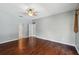 A spacious bedroom with dark wood floors and a ceiling fan offers ample room to relax and unwind at 9491 Wickham Way, Orlando, FL 32836