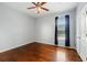 A serene bedroom features a ceiling fan, dark window treatments, and beautiful wood floors at 9491 Wickham Way, Orlando, FL 32836