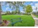 Lush community green space with benches and sports courts under a partly cloudy sky at 9491 Wickham Way, Orlando, FL 32836