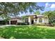 Beautifully landscaped single-story home featuring a lush green lawn and elegant architectural details at 9491 Wickham Way, Orlando, FL 32836