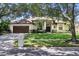 Charming single-story home with a two-car garage, manicured lawn, and mature trees providing ample shade at 9491 Wickham Way, Orlando, FL 32836