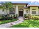 Close-up of the home's front entrance, showcasing lush landscaping and architectural charm at 9491 Wickham Way, Orlando, FL 32836