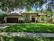 Charming single-story home featuring a well-manicured lawn, lush landscaping, and a welcoming front entrance at 9491 Wickham Way, Orlando, FL 32836